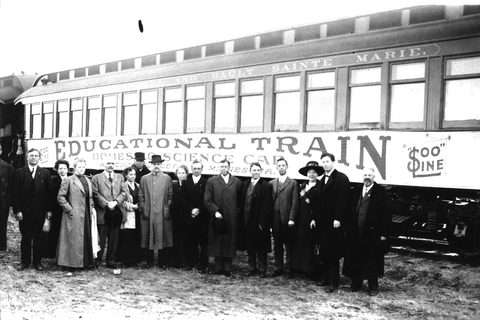 Education train from early 1900s with 15 men and women in front of it