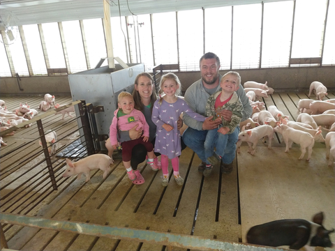 The Selvik family with piglets in the background