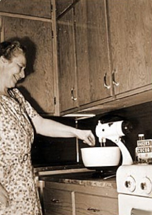 Woman using electric mixer in her home