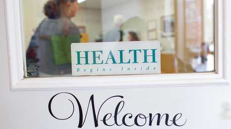 A welcome sign on the entry door to a health clinic