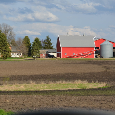 Farmstead with red barn and grain storage.
