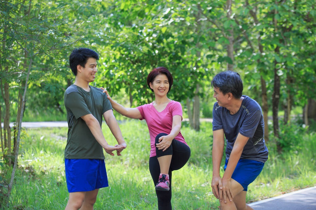 Three family members performing stretches outdoors