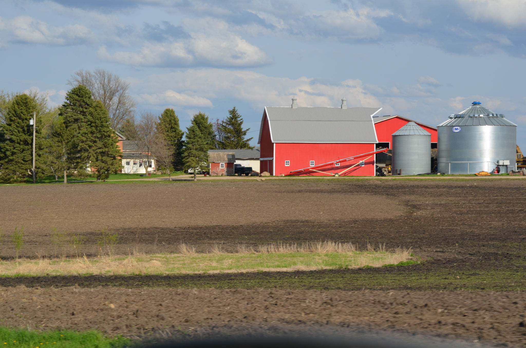 Farmstead with red barn and silos.