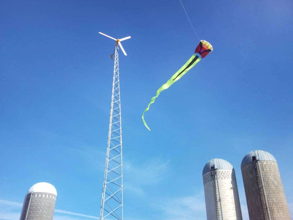 Kite and wind turbine with a bright blue sky