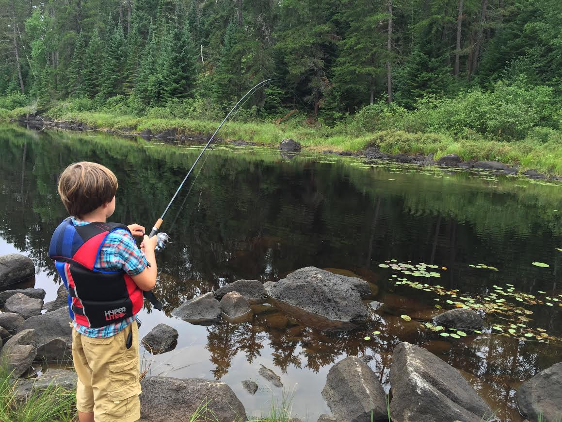 Boy fishing in a river.