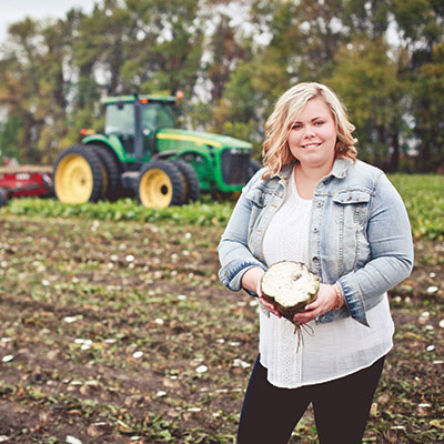 Woman in field holding sugar beet