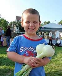 Young boy with onions at farmers market