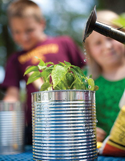 Plant in can with kids in background