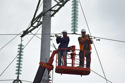 Workers fixing an electrical power line.