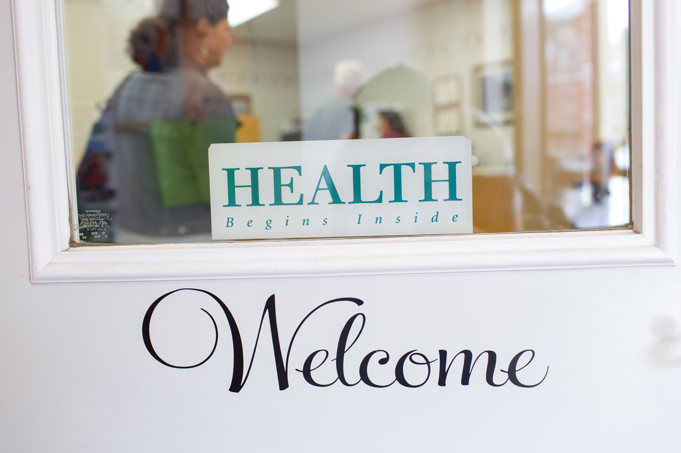 A welcome sign on the entry door to a health clinic