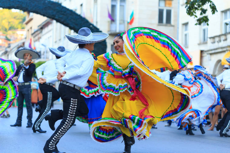 Dancers in cultural clothing performing at an outdoor street festival