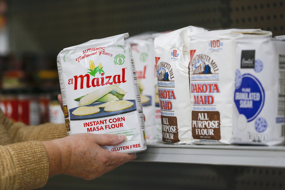 A person stocking masa flour at a food shelf