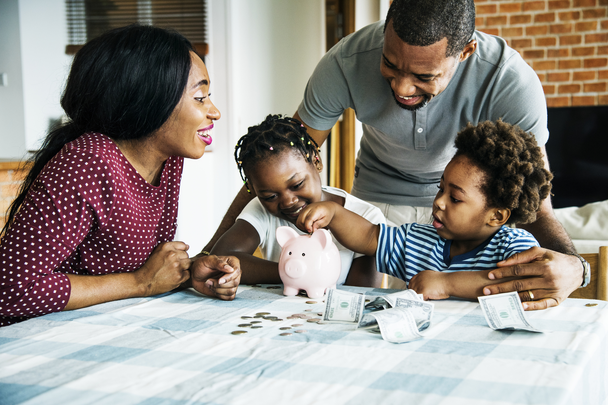 Family at a table placing money in a bank