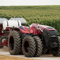 A automatic tractor on a dirt road by a field.