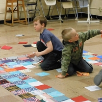 Four children design the quilt square placement