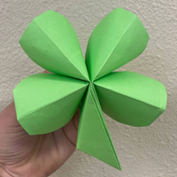 A close up of a green origami paper four leaf clover.