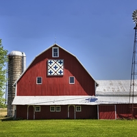 Red dairy barn with silo and windmill on a farm