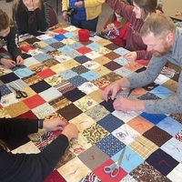 Seven people quilting together