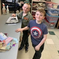 boys iron quilt squares and smile for the camera