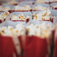 A close up of red paper bags filled with popcorn.