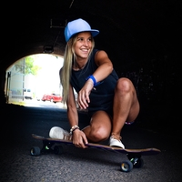 A girl riding a skateboard through a tunnel.