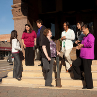Seven women in leadership from diverse age and racial groups conversing and uplifting each other.