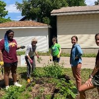 A group of youth with Master Gardener volunteers in a garden