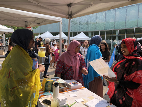 Two Somali women speaking at an outreach booth for the 40-day project