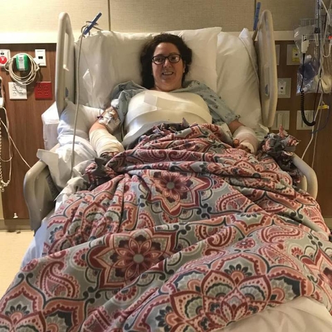 Anna Peterson in a hospital bed covered with a bright patterned blanket her daughter made.