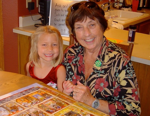 Grandmother and granddaughter complete a puzzle together