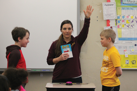 UMN Extension educator leading a classroom activity with two students.