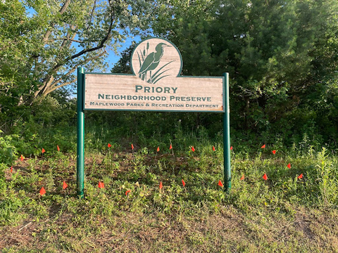 A sign by trees that reads, "Priory Neighborhood preserve."