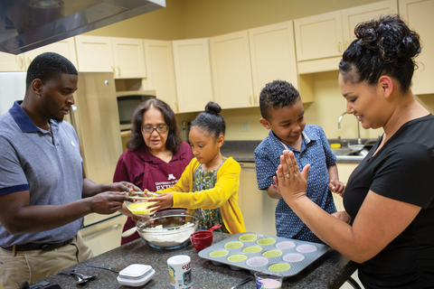 Snap-Ed educators leading a cooking activity with two kids and an adult.