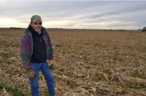 Jerry Ackerman standing in a harvested field.