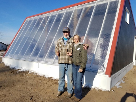Shayne and Louise Johnson standing in front of their Deep Winter Greenhouse