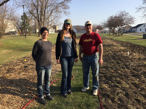 Veronica Shukla, Kimberly Rockman and Gary Wyatt standing on grass next to a row of plantings for the Food Forest.