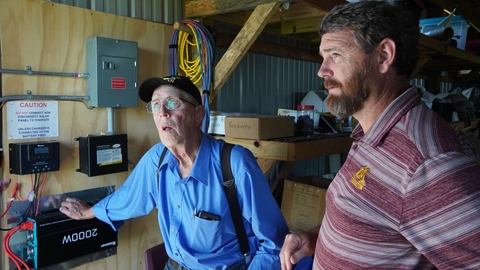 Wayne Kilen & Shannon Mortenson looking at solar panel control center.