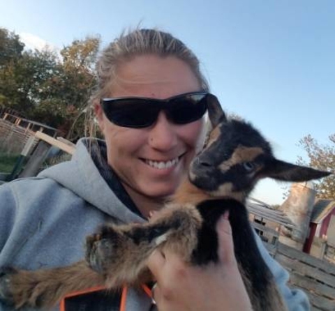 Tiffany Farrier holding a goat.