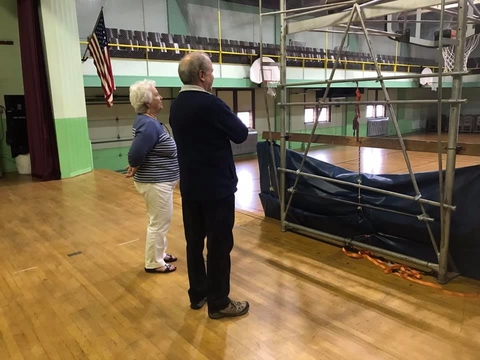 Two adults standing inside an old auditorium