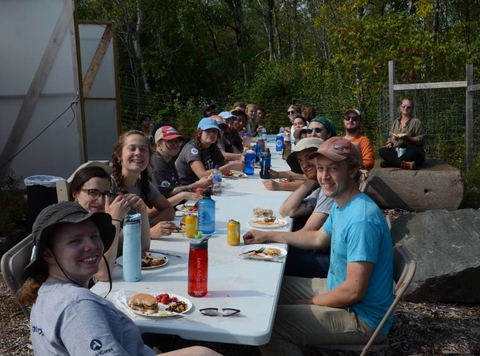 Group of AmeriCorp VISTA members eating around a long table.