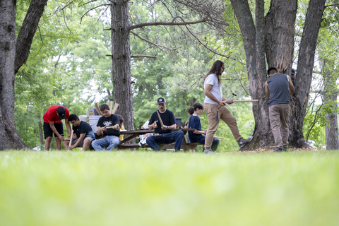 youth sitting in a group underneath trees