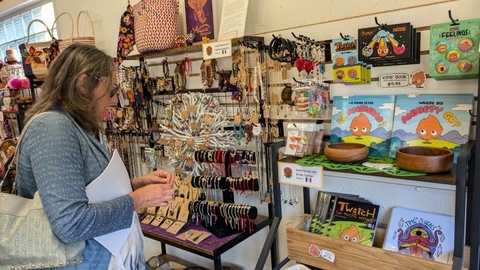 Woman on the left holding an object she is looking in a store.