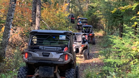 People driving ATVs on a dirt road