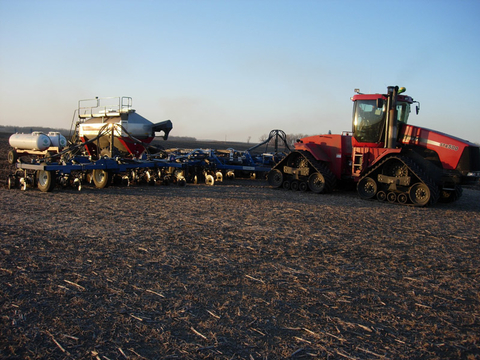 tractor applying fertilizer to a flat field.