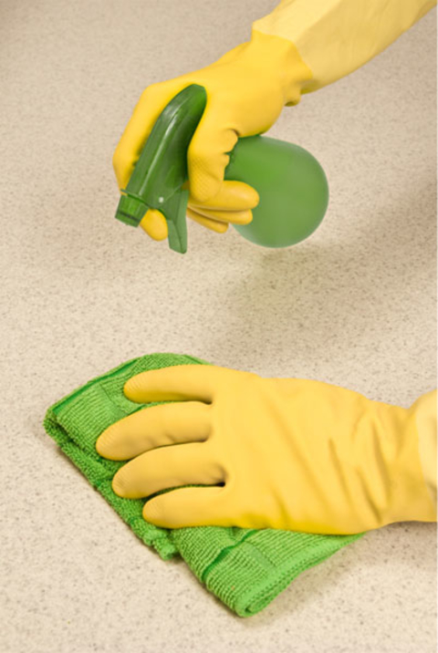 Spraying and wiping counter with gloves on.
