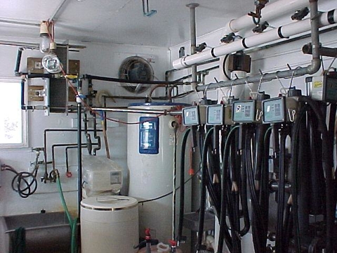 Room with water heater, sink, pipes and hoses
