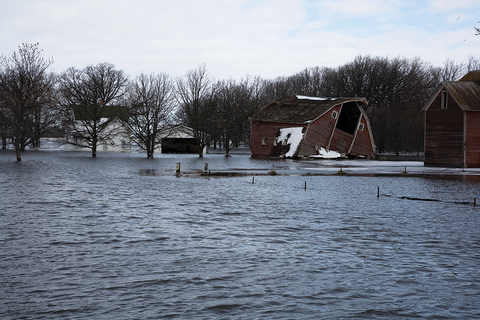 Flooded farm with damaged barn.
