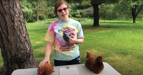 4-H'er showing chickens outside