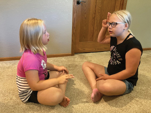 4-H sisters practicing sign language