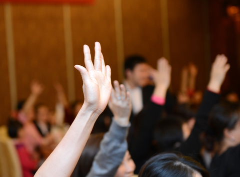 Raised hands in a meeting